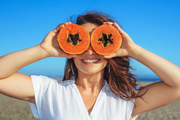 summer nutrition woman with papaya summer nutrition tips